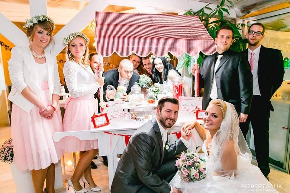Novomanželia so svadobnými hosťami pri candy vozíku